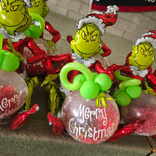 Grinch Sitting with a Merry Christmas "POP" Balloon with 24 Candy Canes Stuffed inside - UpUpNAwayBalloons